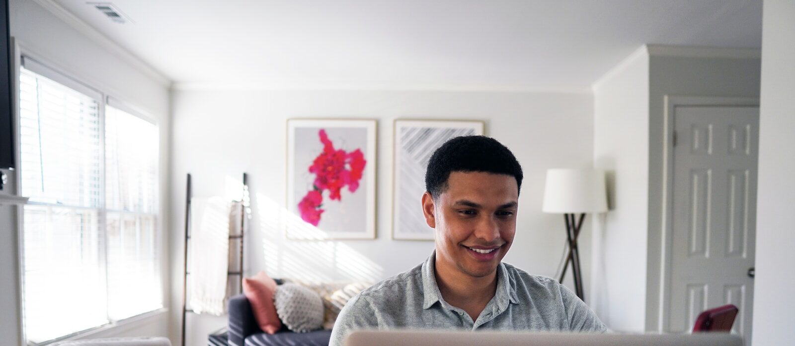 man in gray hoodie sitting on chair in front of silver macbook